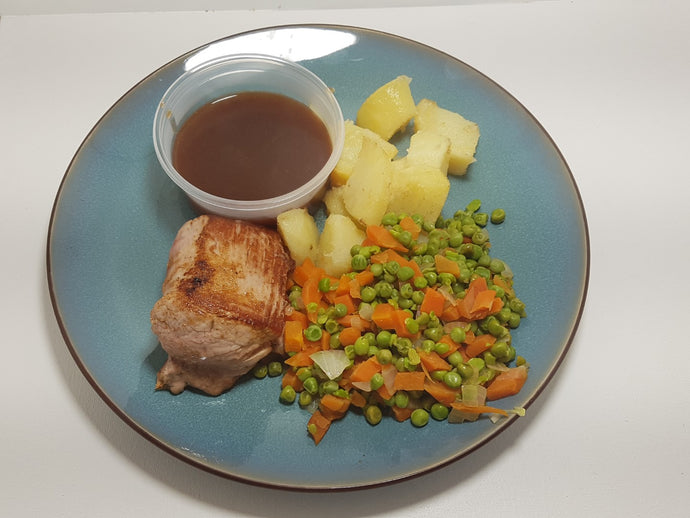 Varkenshaasje met erwtjes en wortelen en gebakken aardappelen
